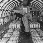 The crew of a Douglas C-47 Skytrain load up a cargo of milk in Frankfurt Rhine-Main, part of the Berlin airlift during the Berlin Blockade, August 1948. The Soviet Union had blocked Allied access to West Berlin by land. (Photo by Henry Grant Compton/FPG/Getty Images)